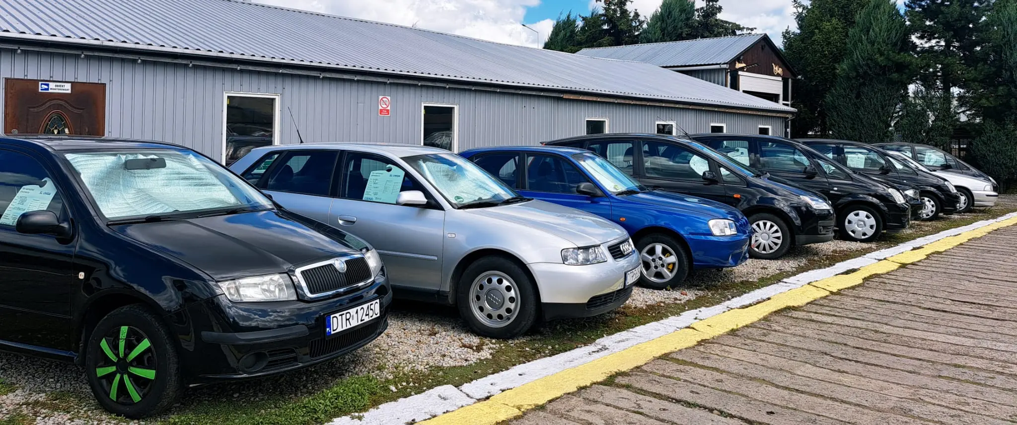 Auta na sprzedaż ustawione w rzędzie na placu Komisu Prusice